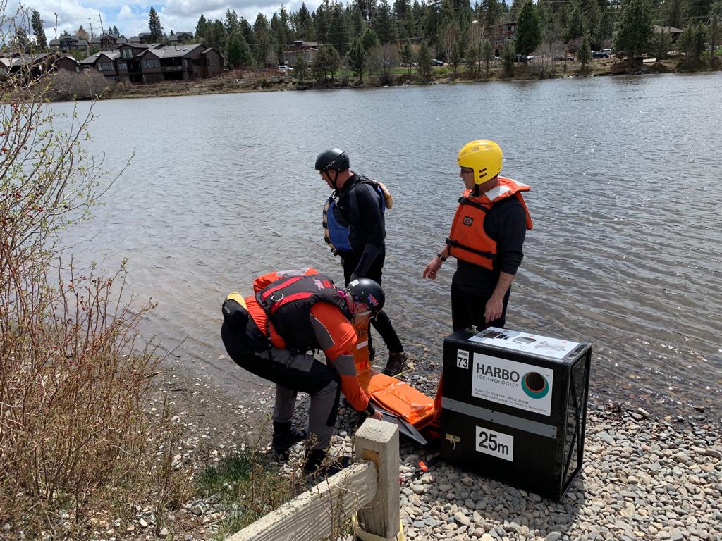 technicians on a river bank prepering to deploy a HARBO boom