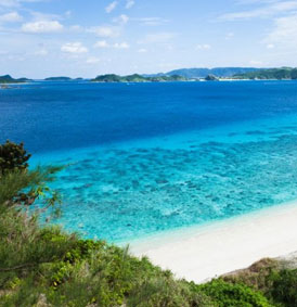 white shoreline, blue water, mountains in the back